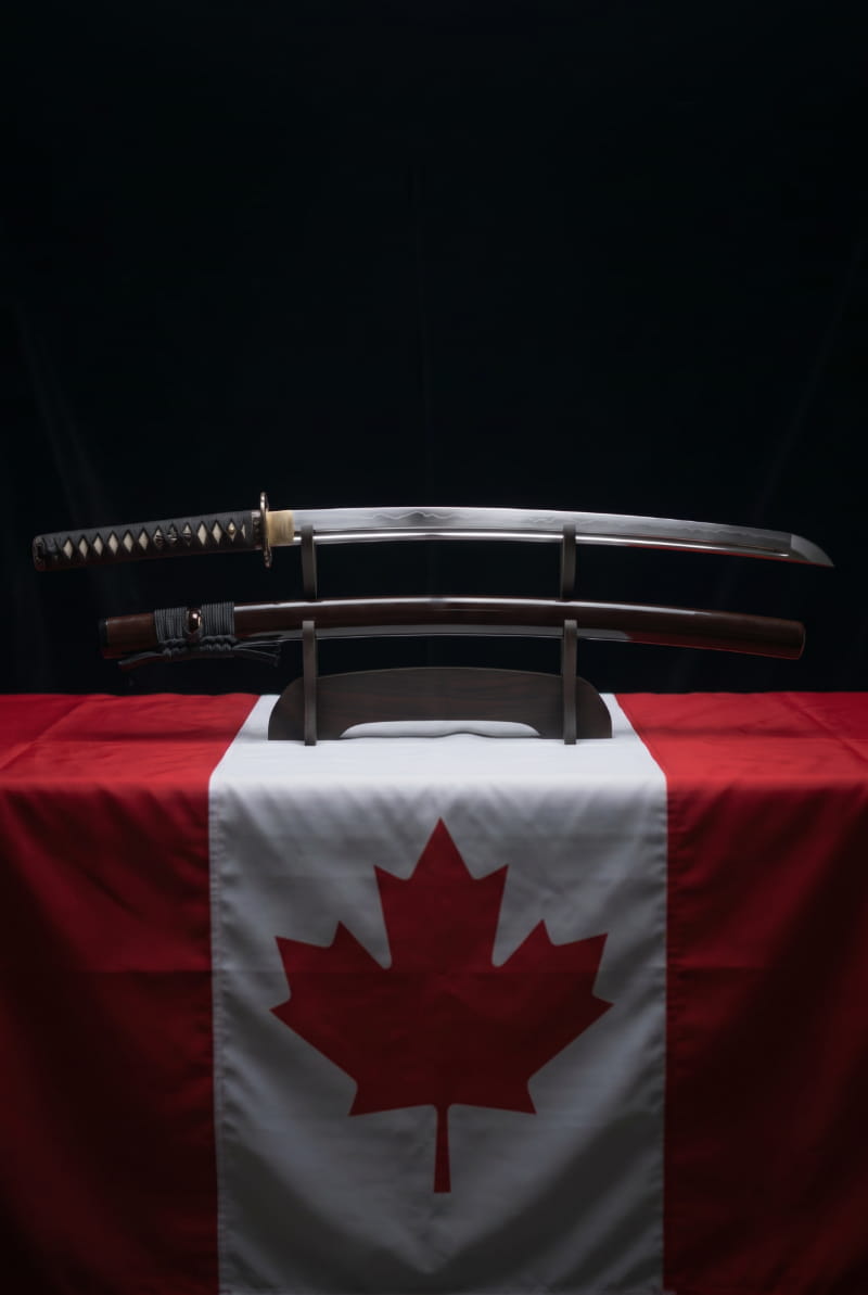 Katana displayed in front of the Canadian flag